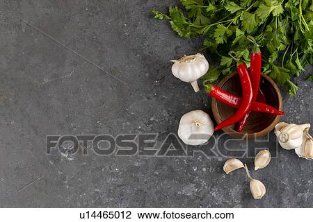 Stock Image - Parsley, garlic and chili peppers. Fotosearch