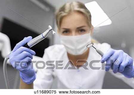 Stock Photography - Patient point of view of dental assistant holding dental equipment. Fotosearch