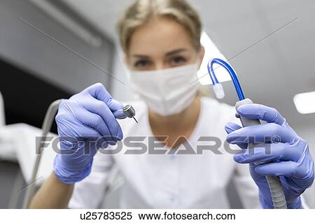Stock Photography - Patient point of view of dental assistant holding dental equipment. Fotosearch