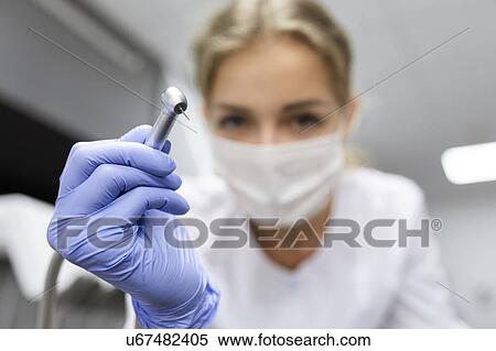 Stock Photography - Patient point of view of dental assistant holding dental equipment. Fotosearch
