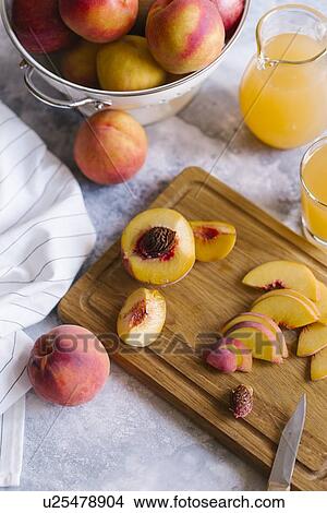 Peaches sliced on wooden cutting board View Large Photo Image Picture - Peaches sliced on wooden cutting board. Fotosearch