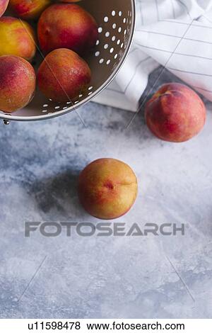 Peaches with colander View Large Photo Image Stock Photo - Peaches with colander. Fotosearch