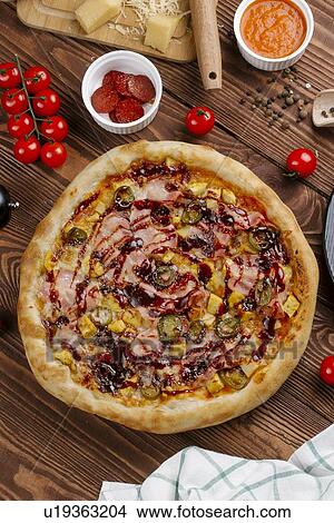 Pizza and ingredients on wooden table View Large Photo Image Picture - Pizza and ingredients on wooden table. Fotosearch
