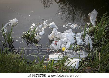 Stock Photo - Plastic garbage dumped into waterway, West Midlands, UK.. Fotosearch