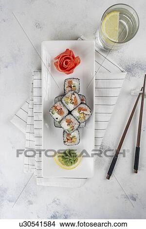 Plate of sushi with chopsticks and drinking glass View Large Photo Image Picture - Plate of sushi with chopsticks and drinking glass. Fotosearch