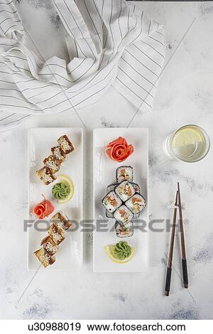 Stock Photo - Plates of sushi with chopsticks and drinking glass. Fotosearch