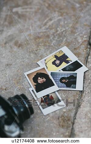 Stock Photo - Polaroid photographs of young woman by camera. Fotosearch