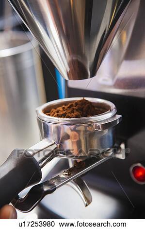 Stock Image - Portafilter catching ground coffee. Fotosearch