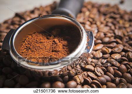 Portafilter holding ground coffee on roasted coffee beans View Large Photo Image Stock Photograph - Portafilter holding ground coffee on roasted coffee beans. Fotosearch