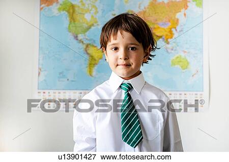 Stock Photo - Portrait of boy in school uniform, World map in background. Fotosearch