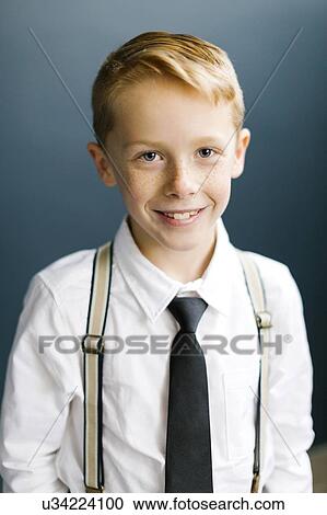 Stock Image - Portrait of smiling boy wearing tie. Fotosearch