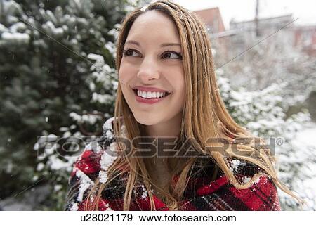 Stock Photo - Portrait of smiling young woman in snow. Fotosearch