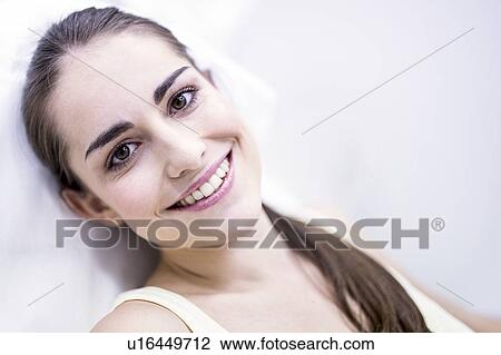 Portrait of smiling young woman sitting on chair in clinic, close-up. View Large Photo Image Stock Image - Portrait of smiling young woman sitting on chair in clinic, close-up.. Fotosearch