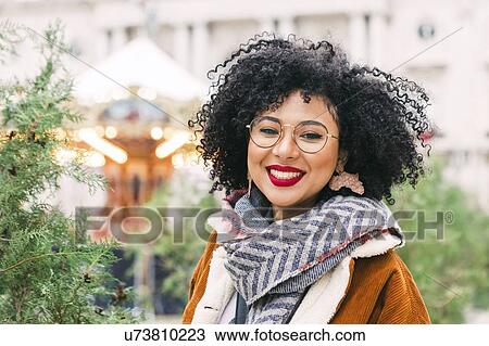 Stock Image - Portrait of smiling young woman wearing glasses and red lipstick. Fotosearch