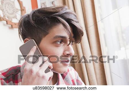 Stock Photo - Portrait of teenage boy on phone call. Fotosearch