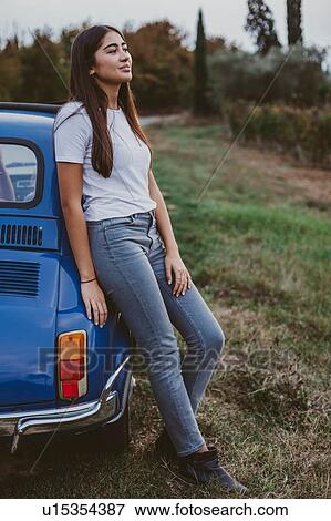 Stock Photo - Portrait of woman leaning against car in countryside, Florence, Toscana, Italy. Fotosearch