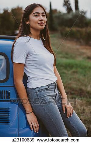 Stock Photo - Portrait of woman leaning against car in countryside, Florence, Toscana, Italy. Fotosearch