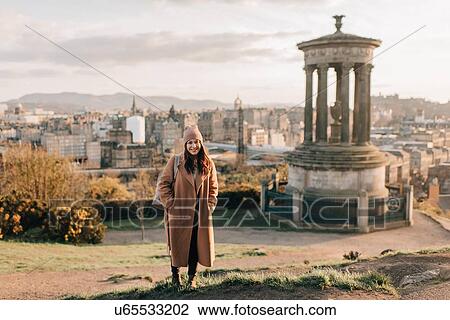 Stock Image - Portrait of woman near historic monument, Calton Hill, Edinburgh, Scotland. Fotosearch