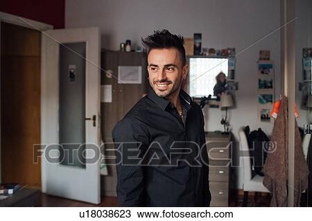 Portrait of young man in room View Large Photo Image Stock Image - Portrait of young man in room. Fotosearch