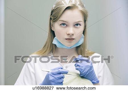 Portrait of young woman holding dentist equipment View Large Photo Image Stock Photo - Portrait of young woman holding dentist equipment. Fotosearch