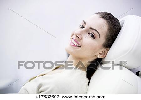 Stock Image - Portrait of young woman lying on couch in clinic.. Fotosearch