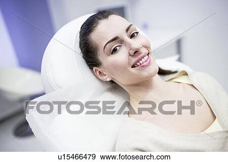 Stock Photo - Portrait of young woman lying on couch in clinic.. Fotosearch