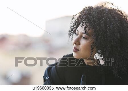 Stock Photography - Portrait of young woman with curly black hair. Fotosearch