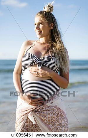 Stock Image - Pregnant woman on beach. Fotosearch