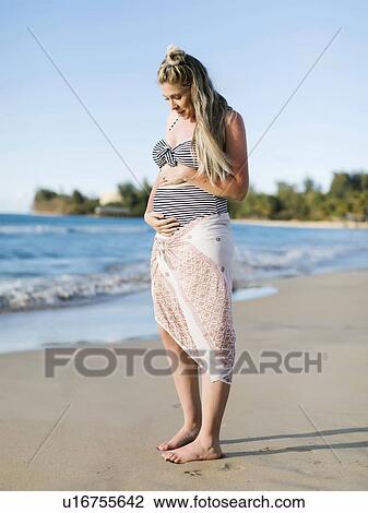 Stock Image - Pregnant woman on beach. Fotosearch