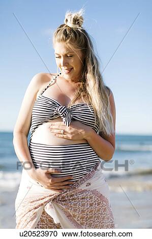 Stock Image - Pregnant woman on beach. Fotosearch