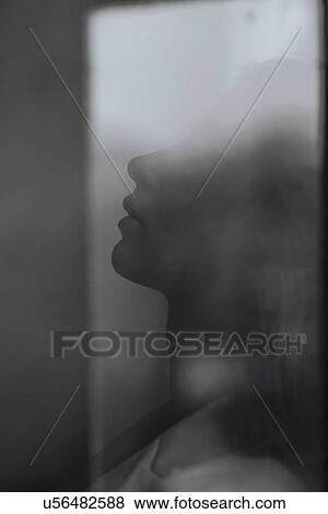 Profile of young woman behind window View Large Photo Image Stock Photo - Profile of young woman behind window. Fotosearch
