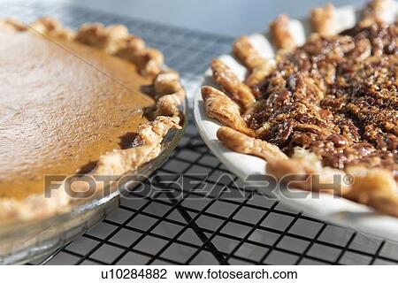 Stock Image - Pumpkin and pecan pies on a cooling rack. Fotosearch