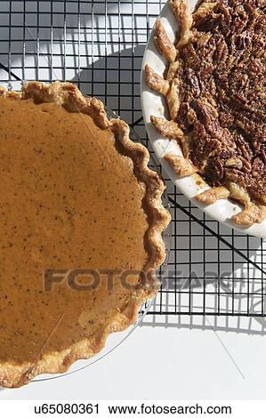 Pumpkin and pecan pies on a cooling rack View Large Photo Image Stock Image - Pumpkin and pecan pies on a cooling rack. Fotosearch