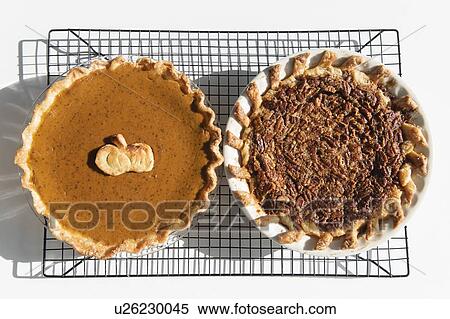 Stock Photography - Pumpkin and pecan pies on a cooling rack. Fotosearch