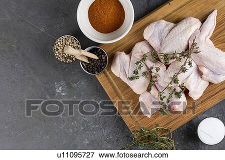 Raw chicken on cutting board with herb and spices View Large Photo Image Stock Photo - Raw chicken on cutting board with herb and spices. Fotosearch