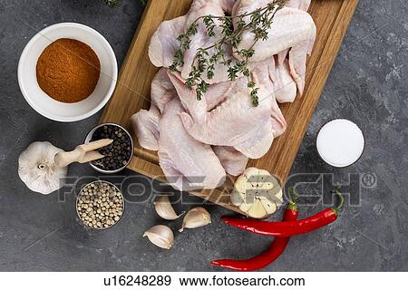Raw chicken on cutting board with herb and spices View Large Photo Image Stock Photo - Raw chicken on cutting board with herb and spices. Fotosearch