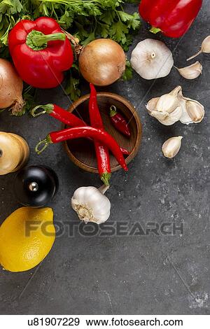 Stock Photo - Raw vegetable ingredients with chili peppers. Fotosearch
