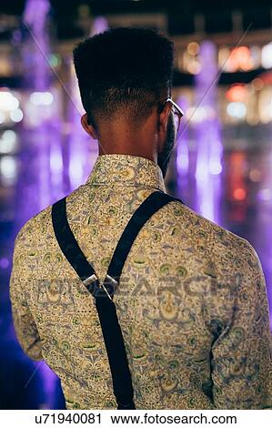 Stock Image - Rear view of man wearing suspenders over shirt. Fotosearch