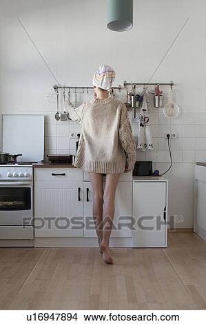 Rear view of young woman in apartment kitchen View Large Photo Image Picture - Rear view of young woman in apartment kitchen. Fotosearch