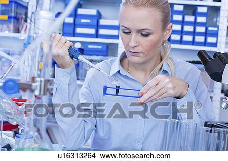 Picture - Researcher pipetting sample.. Fotosearch