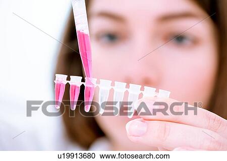 Stock Image - Researcher pipetting sample.. Fotosearch