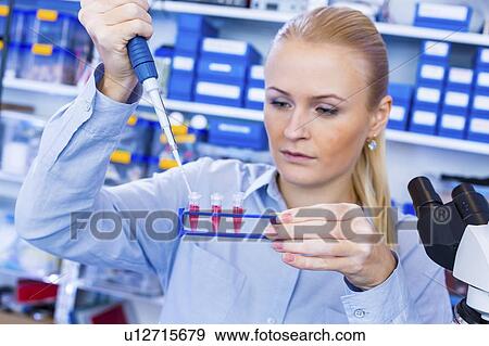 Stock Photo - Researcher pipetting sample.. Fotosearch