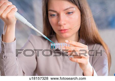 Stock Photo - Researcher pipetting sample.. Fotosearch