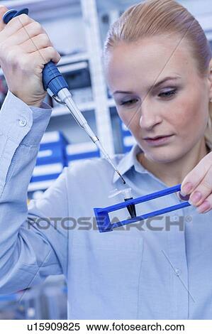 Stock Photography - Researcher pipetting sample.. Fotosearch