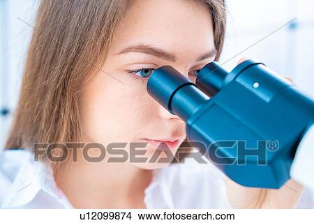 Picture - Researcher using microscope.. Fotosearch