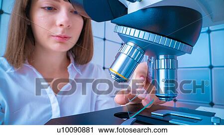 Stock Image - Researcher using microscope.. Fotosearch