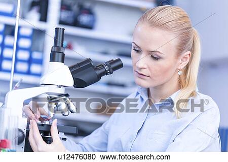 Stock Image - Researcher using microscope.. Fotosearch