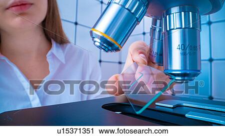 Stock Image - Researcher using microscope.. Fotosearch