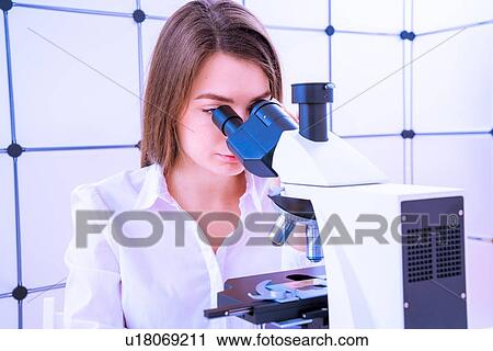 Stock Image - Researcher using microscope.. Fotosearch