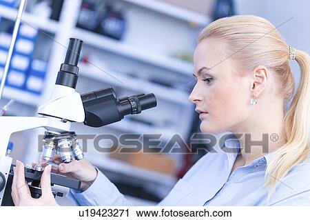 Stock Image - Researcher using microscope.. Fotosearch